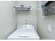 Bright laundry area showcases a modern washing machine and overhead storage shelf at 1942 Bermuda Pointe Dr, Haines City, FL 33844