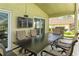 Covered patio features an outdoor dining set, a television, and a modern grill at 1942 Bermuda Pointe Dr, Haines City, FL 33844