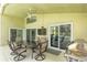 Covered outdoor patio with a ceiling fan, television, dining table, and gas grill perfect for entertaining guests at 1942 Bermuda Pointe Dr, Haines City, FL 33844