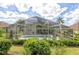 Screened-in pool area featuring a refreshing pool, lush landscaping, and comfortable seating at 1942 Bermuda Pointe Dr, Haines City, FL 33844