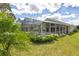 View of the screened-in pool area, outdoor seating, and lush backyard landscaping at 1942 Bermuda Pointe Dr, Haines City, FL 33844