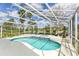 Sparkling pool area under screened-in enclosure, with ample seating and lush landscaping at 1942 Bermuda Pointe Dr, Haines City, FL 33844