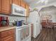 Kitchen features white appliances and adjacent dining area at 2055 S Floral Ave # 42, Bartow, FL 33830