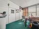 Enclosed porch with white walls, green carpet, and access door, offering extra living space at 2055 S Floral Ave # 42, Bartow, FL 33830