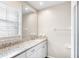 Bathroom featuring granite countertops, white cabinets, and a window for natural light at 2096 Lake Ariana Blvd, Auburndale, FL 33823