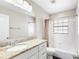 Bathroom featuring granite countertops, white cabinets, and a tiled shower/tub combo at 2096 Lake Ariana Blvd, Auburndale, FL 33823