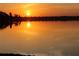 Serene lake view at sunset with calm water and a bright, golden sun at 2096 Lake Ariana Blvd, Auburndale, FL 33823