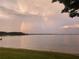 Scenic lake view with a vibrant rainbow arcing across the horizon, offering serene beauty at 2096 Lake Ariana Blvd, Auburndale, FL 33823
