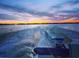 Beautiful sunset view from a boat showcasing a powerful engine and tranquil water at 2096 Lake Ariana Blvd, Auburndale, FL 33823