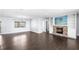 Expansive living room with dark wood flooring, fireplace with TV, and an additional room for a versatile living space at 2096 Lake Ariana Blvd, Auburndale, FL 33823