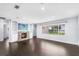 Light-filled living room with dark floors, a brick fireplace and a large window at 2096 Lake Ariana Blvd, Auburndale, FL 33823