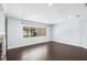 Bright living room with a large window and dark wood flooring that creates a modern yet inviting atmosphere at 2096 Lake Ariana Blvd, Auburndale, FL 33823
