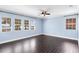 Spacious room with light blue walls, multiple view windows, ceiling fan, and dark wood-style flooring at 2096 Lake Ariana Blvd, Auburndale, FL 33823