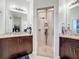 Bathroom featuring double vanities and a tiled walk-in shower with built in shelving at 229 Elm Ct, Kissimmee, FL 34759
