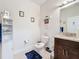 Well-lit bathroom with a vanity, toilet, and decorative wall art at 229 Elm Ct, Kissimmee, FL 34759