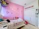 Whimsical bedroom featuring pink wall decor, playful artwork, and ample closet space at 229 Elm Ct, Kissimmee, FL 34759
