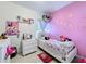 Vibrant bedroom with pink walls, decorative art, and playful decor at 229 Elm Ct, Kissimmee, FL 34759