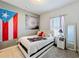 Cozy bedroom with a neutral color scheme, flag decor, and a comfortable-looking bed at 229 Elm Ct, Kissimmee, FL 34759