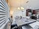 Dining room with modern lighting and adjacent kitchen, ideal for entertaining guests at 229 Elm Ct, Kissimmee, FL 34759