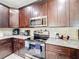 Kitchen showcasing stainless steel appliances, granite countertops, and dark wood cabinets for a sleek design at 229 Elm Ct, Kissimmee, FL 34759