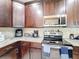 A corner kitchen showcasing stainless steel appliances, granite countertops, and dark wood cabinets for a sleek design at 229 Elm Ct, Kissimmee, FL 34759