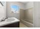 Bathroom featuring a tiled shower-tub, updated vanity and window at 2301 Freemason St, Lakeland, FL 33801