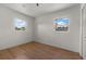 Bright bedroom with wood floors, white walls, and two windows providing natural light at 2301 Freemason St, Lakeland, FL 33801