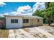 Charming single-story home featuring a combination of white and yellow exterior with a well-maintained front yard and a concrete driveway at 2301 Freemason St, Lakeland, FL 33801