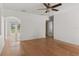 A bright living room with wood floors, white walls, and a ceiling fan, and arched entryway at 2301 Freemason St, Lakeland, FL 33801