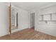 Bright living room featuring wood floors, built-in shelving, and white walls with an open doorway to the kitchen at 2301 Freemason St, Lakeland, FL 33801
