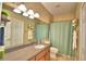 Bathroom features a single sink vanity, large mirror, and a shower with light-blue curtain at 2654 Rutledge Ct, Winter Haven, FL 33884