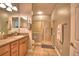 Bright bathroom featuring a glass-enclosed shower, vanity with double mirrors and tiled floors at 2654 Rutledge Ct, Winter Haven, FL 33884