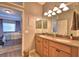 Bathroom featuring double sinks, wood cabinets and a peek into the primary bedroom at 2654 Rutledge Ct, Winter Haven, FL 33884