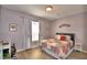 Cozy bedroom with a charming patchwork quilt, wood floor, and soft natural light from the window at 2654 Rutledge Ct, Winter Haven, FL 33884