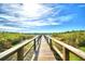 Picturesque wooden boardwalk over a serene lake surrounded by lush vegetation and a clear sky at 2654 Rutledge Ct, Winter Haven, FL 33884