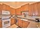 This kitchen features wood cabinets, a white stove, and a stainless steel dishwasher at 2654 Rutledge Ct, Winter Haven, FL 33884