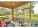 Outdoor lanai seating area with two chairs and a table, offering a relaxing view of the lush landscaping at 2654 Rutledge Ct, Winter Haven, FL 33884