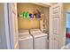 Functional laundry room with white washer and dryer, shelving, and storage for cleaning supplies at 2654 Rutledge Ct, Winter Haven, FL 33884