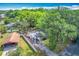 Overhead view of the home featuring lush surrounding trees, carport, and a long driveway at 320 S Elm Rd, Lakeland, FL 33801
