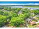 An aerial view showing the surrounding area, lush trees, and a scenic lake at 320 S Elm Rd, Lakeland, FL 33801