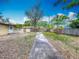 View of the backyard with a concrete walkway, fenced perimeter, and potential for a beautiful garden at 320 S Elm Rd, Lakeland, FL 33801