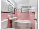 Retro bathroom with pink tile, pedestal sink, and a bathtub-shower combination for a classic look at 320 S Elm Rd, Lakeland, FL 33801