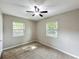 Bedroom featuring two windows providing natural light, ceiling fan, and neutral carpet at 320 S Elm Rd, Lakeland, FL 33801