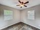 Bedroom featuring two windows providing natural light, ceiling fan, and plank flooring at 320 S Elm Rd, Lakeland, FL 33801