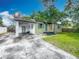 Home featuring a carport, well-kept lawn and exterior, creating inviting curb appeal at 320 S Elm Rd, Lakeland, FL 33801