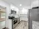 Recently renovated kitchen boasts stainless appliances, granite counters, and white cabinets at 320 S Elm Rd, Lakeland, FL 33801