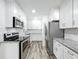 Gorgeous kitchen featuring new stainless steel appliances, granite counters, and subway tile backsplash at 320 S Elm Rd, Lakeland, FL 33801