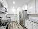 Bright kitchen featuring stainless steel appliances, granite counters, and white cabinets at 320 S Elm Rd, Lakeland, FL 33801