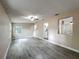 Open living area with gray wood-look floors, and a ceiling fan, leading into the kitchen and other rooms at 320 S Elm Rd, Lakeland, FL 33801