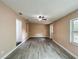 Bright living space with gray wood-look floors, ceiling fan, and a door leading outside, perfect for entertaining at 320 S Elm Rd, Lakeland, FL 33801